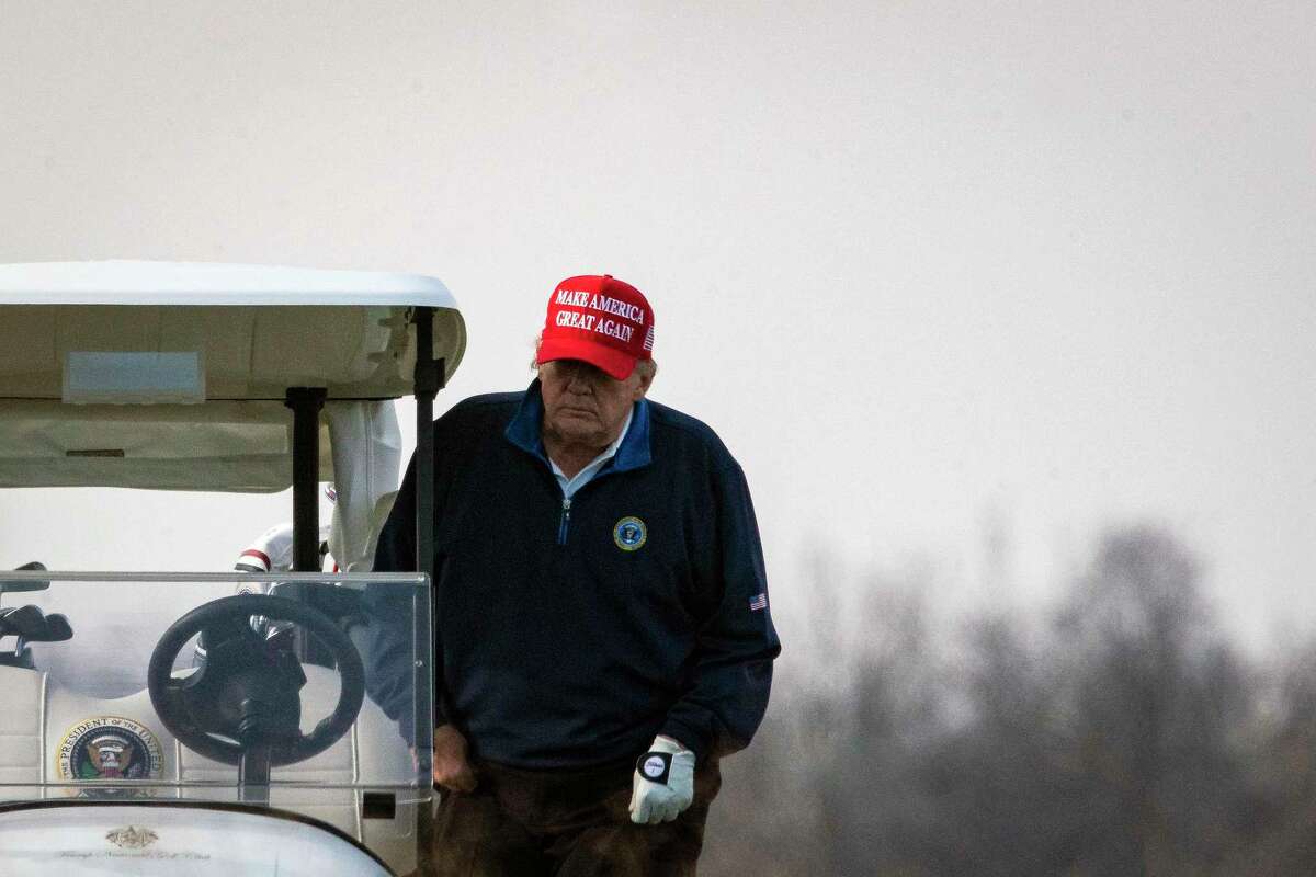 U.S. President Donald Trump climbs into a golf cart as he golfs at Trump National Golf Club on Sunday, Dec. 13, 2020 in Sterling, Virginia.