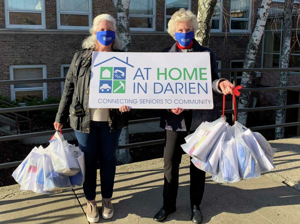 At Home In Darien Board Members Monica Billeter and Robin Woods prepare to deliver gift bags to residents of The Royle.