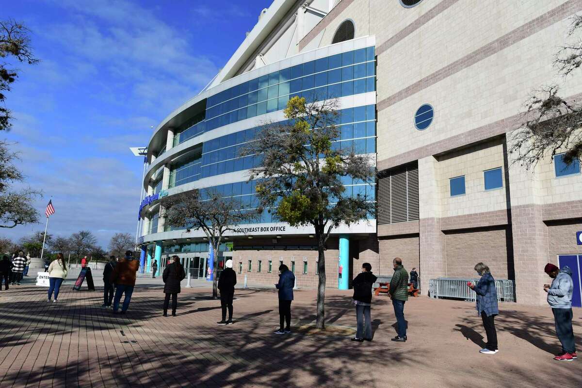 People stand socially distanced in line for no-cost COVID-19 vaccinations at the Alamodome on Monday, Jan. 11, 2021. About 9,000 vaccines will be given at the site this week, or about 1,500 per day, depending on staffing.