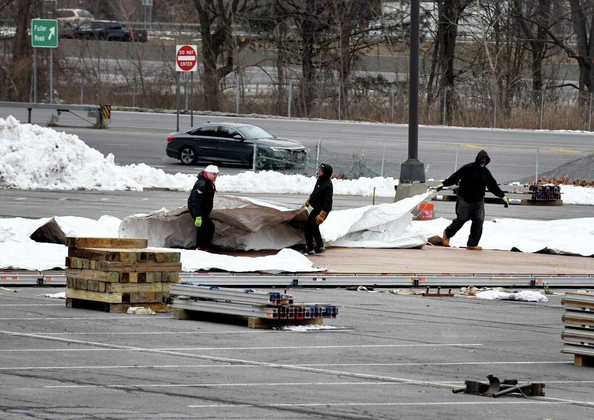 Workers erect a new walk-up vaccination site at the University at Albany in its Northwest Gold parking lot on Monday, Jan. 11, 2021, in Albany, N.Y. The site is said to be operational by Friday. (Will Waldron/Times Union)