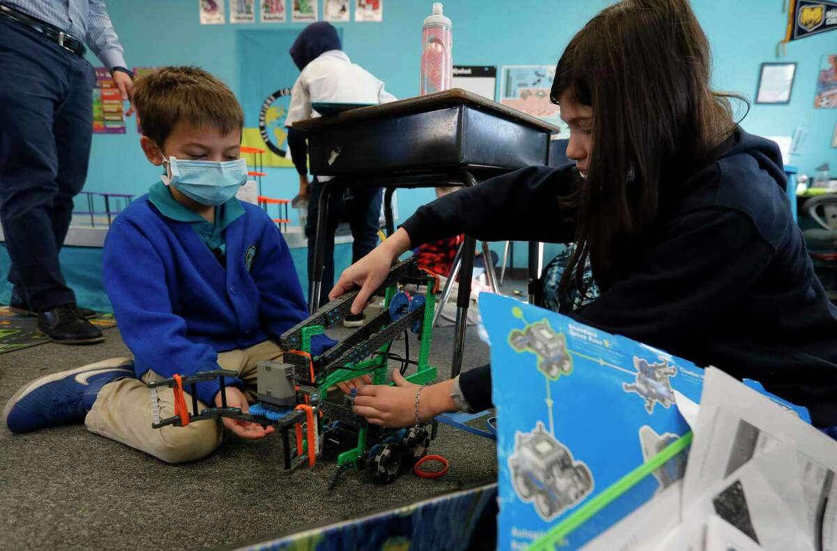 Isaac Wolfard, left, helps set up a robot with Elena Welty during class, Thursday, Jan. 7, 2021. All Nations Community School is partnering with Journey School for the Uniquely Gifted and Talented for a joint after school robotics program.