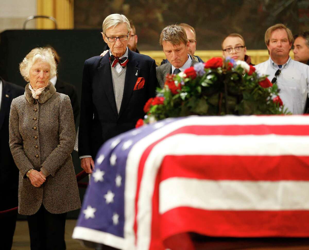 Jonathan Bush, brother of President George H.W. Bush and Nancy Walker Bush Ellis, his sister view his flad draped coffin as he laid in state at the United States Capitol Rotunda, Tuesday, Dec. 4, 2018, in Washington. Bush will lie in state in the Rotunda until Wednesday morning.
