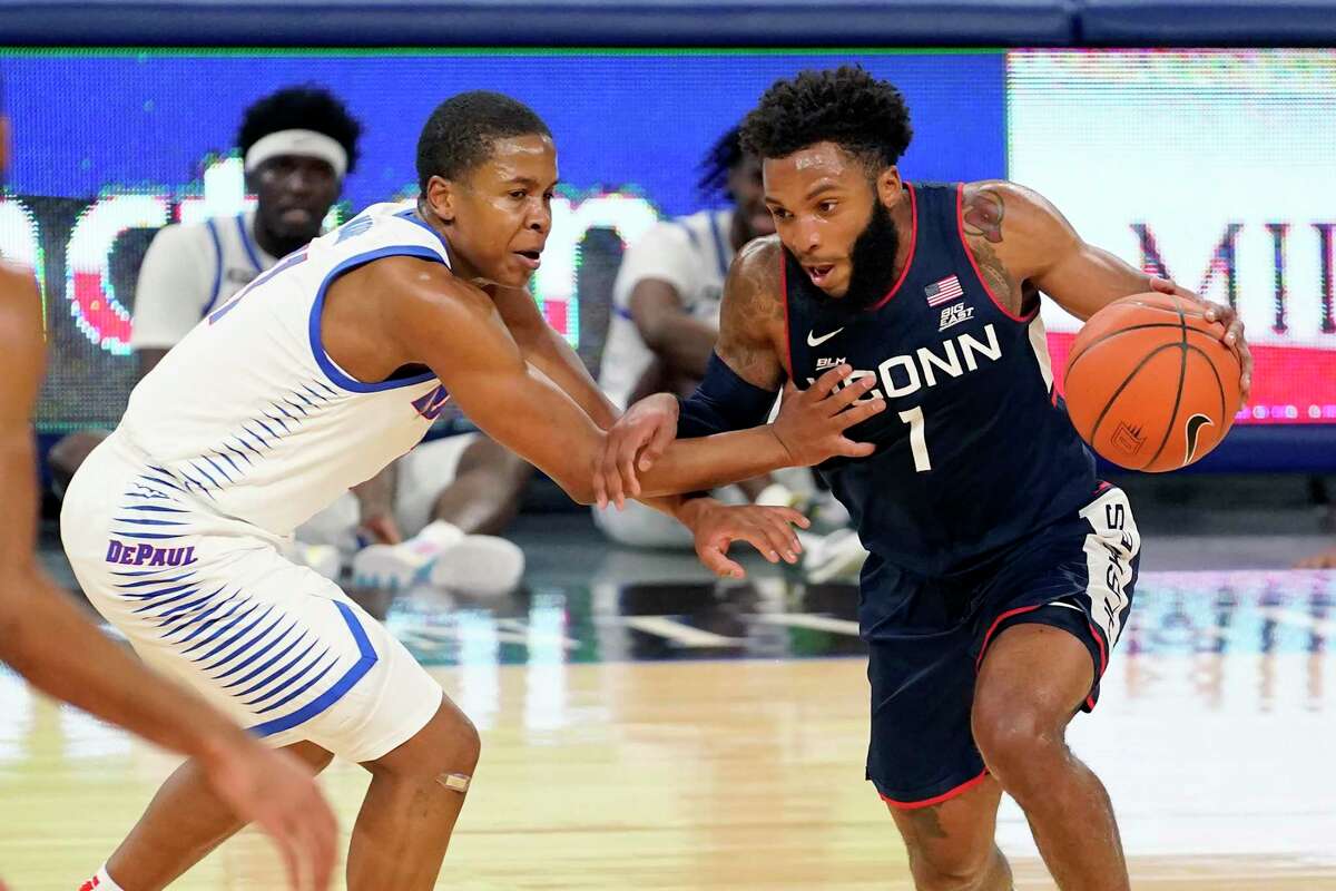 Connecticut's R.J. Cole (1) drives against DePaul's Charlie Moore during the first half of an NCAA college basketball game Monday, Jan. 11, 2021, in Chicago. (AP Photo/Charles Rex Arbogast)