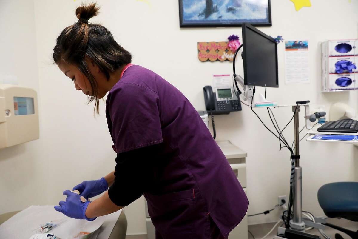 Licensed vocational nurse Jesselle D. Bugarin prepares to administer a pediatric measles, mumps, rubella, and varicella (MMRV) vaccine to a young patient at Kaiser Permanente Redwood City, in Redwood City, Calif., on Friday, April 12, 2019.