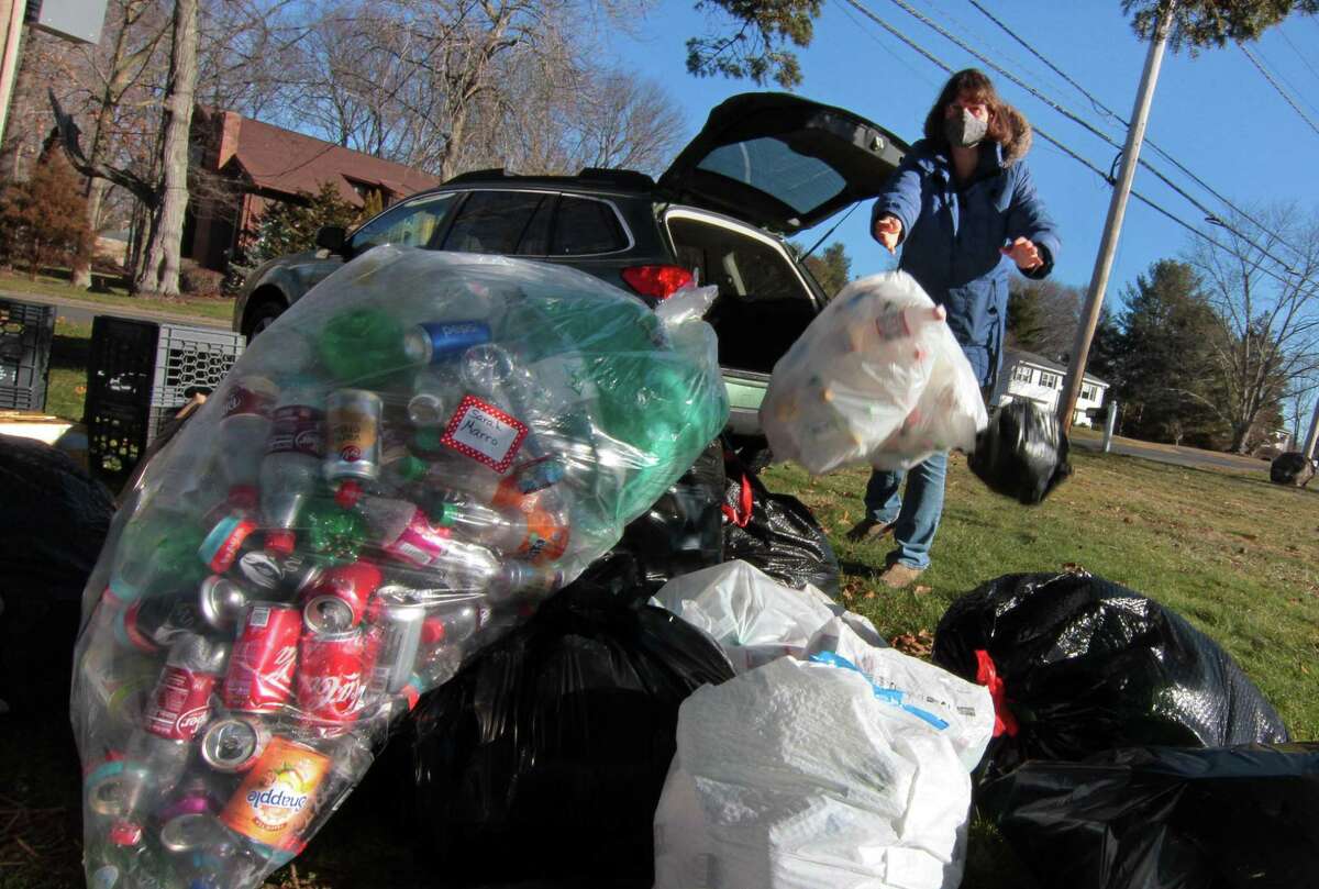 Scout mom Maggie Andrade tosses donated cans and bottles into the growing pile.