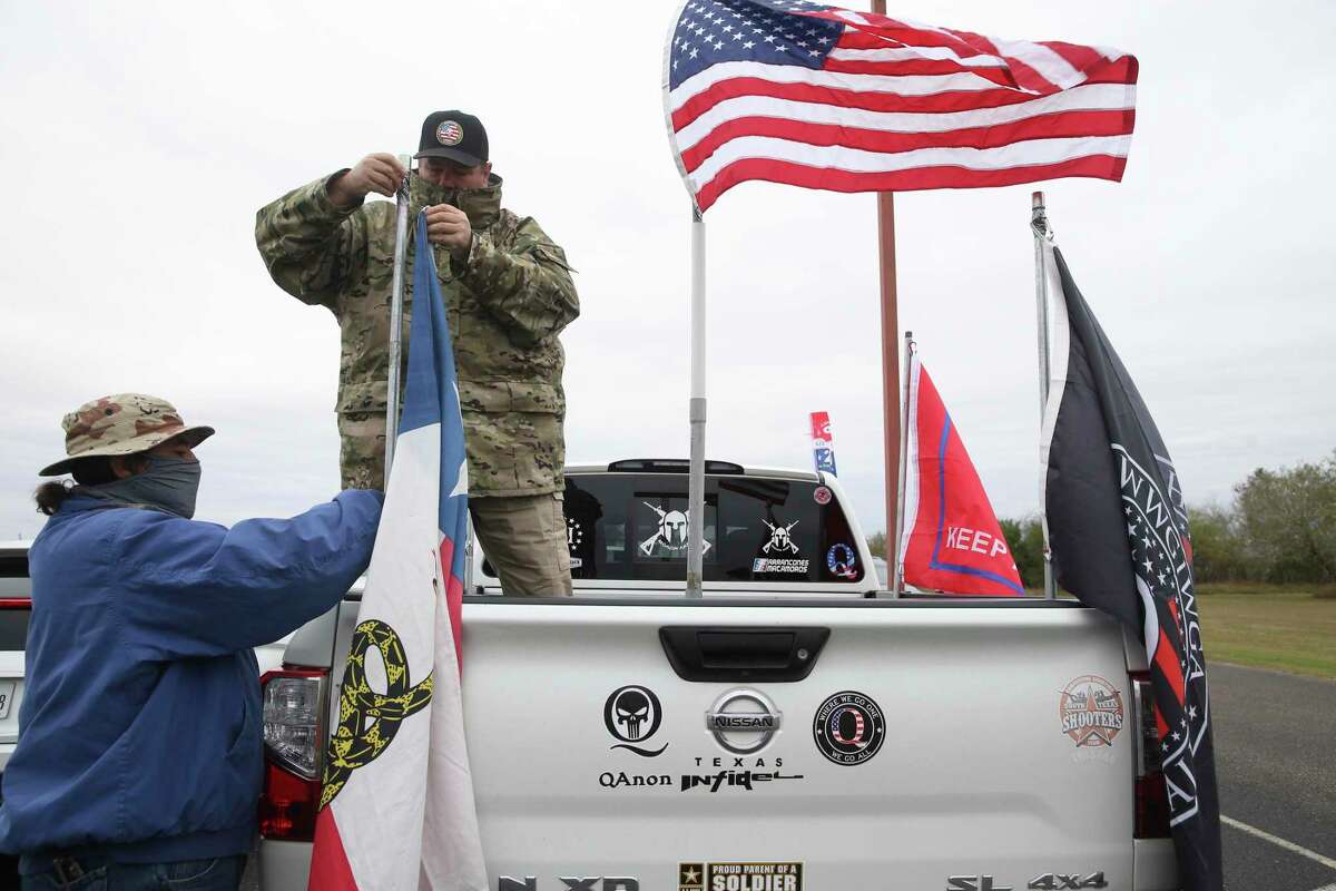 James Lambert, 56, place flags on his truck with the help of a friend at the Christian Fellowship Church in Harlingen, Texas, Tuesday, Jan. 12, 2021. Supporters gathered for President Donald Trump's visit to the Rio Grande Valley and the border wall.