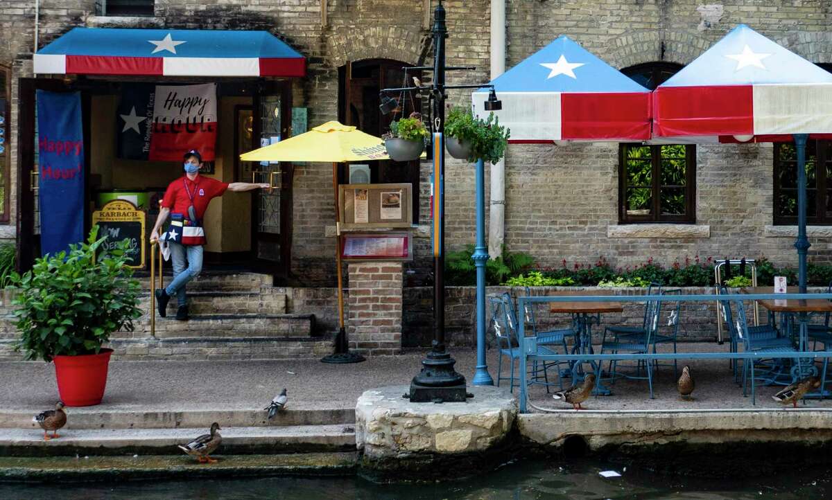 A waiter awaits customers at the Republic of Texas restaurant on the San Antonio River Walk Thursday, Aug. 13, 2020.
