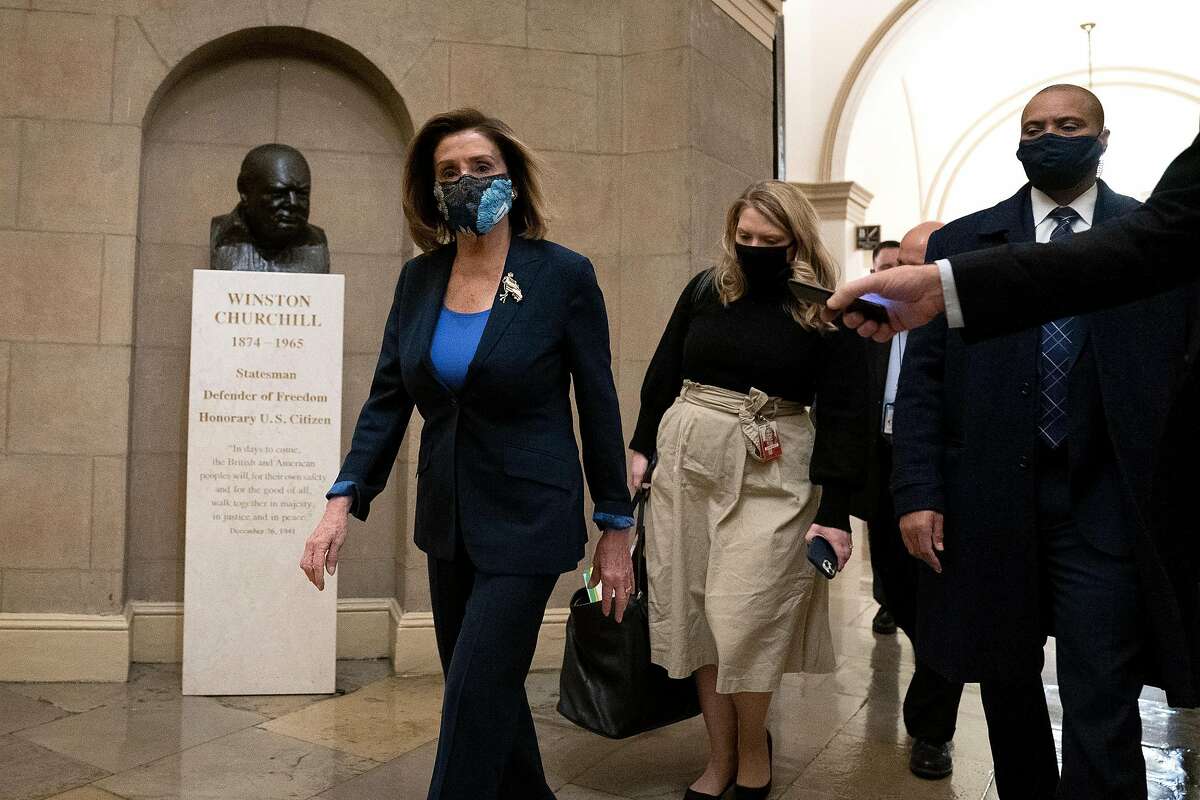 House Speaker Nancy Pelosi, D-San Francisco, (left) wears a protective mask while arriving to the Capitol on Tuesday.