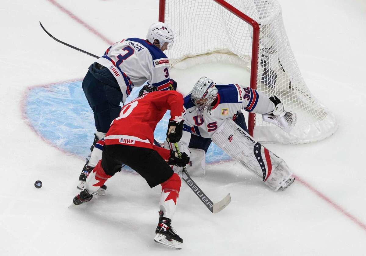 Canada's Dylan Holloway (10) is stopped by U.S. goalie Spencer Knight (30) as Henry Thrun (3) defends during the first period of the championship game in the IIHF World Junior Hockey Championship, Tuesday, Jan. 5, 2021, in Edmonton, Alberta. (Jason Franson/The Canadian Press via AP)