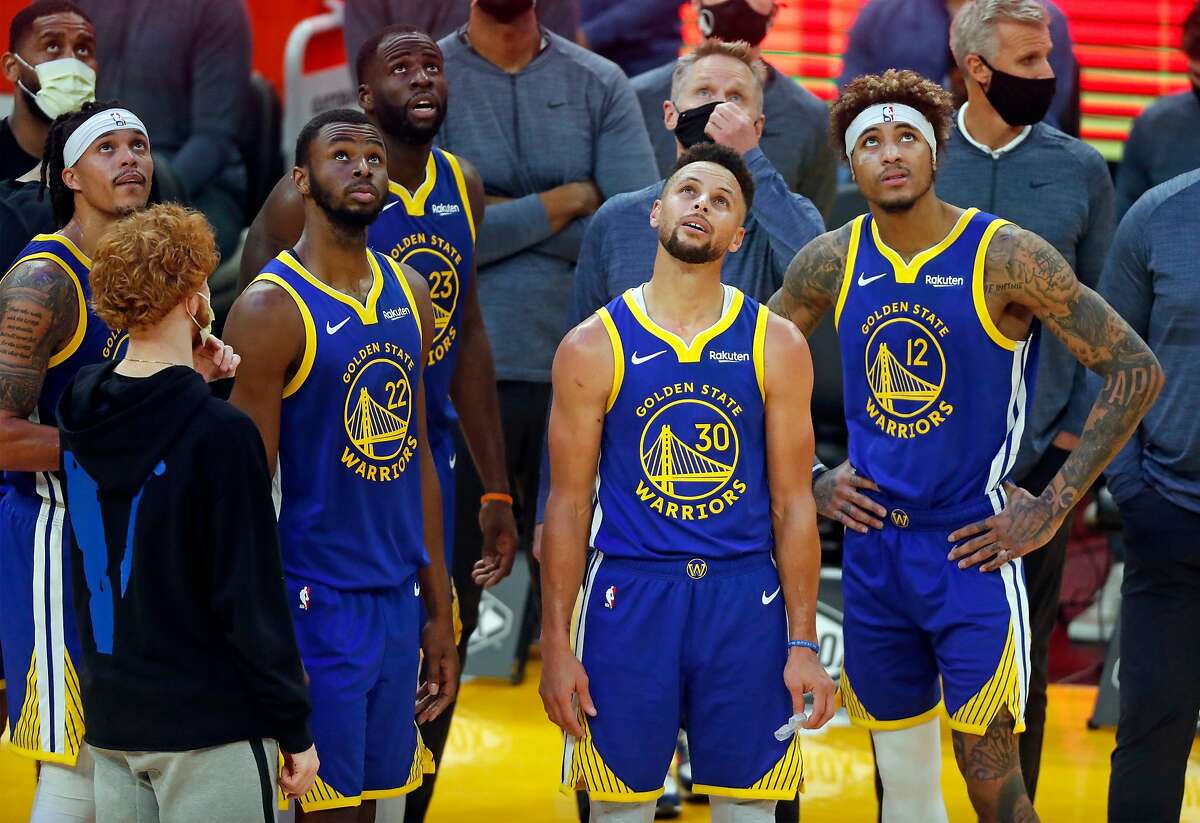 Golden State Warriors' Damion Lee, Andrew Wiggins, Draymond Green, Stephen Curry, Steve Kerr and Kelly Oubre, Jr. watch replay during Indiana Pacers' 104-95 win during NBA game at Chase Center in San Francisco, Calif., on Tuesday, January 12, 2021.