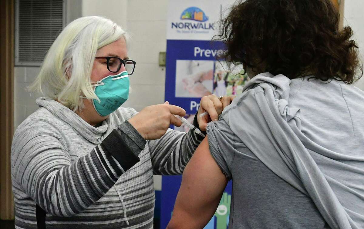 Volunteer Patricia Carey administers the new COVID vaccine to an employee of Silver Hills senior residence as Lt. Governor Bysiewicz, Norwalk Mayor Harry Rilling, Norwalk Department of Health Director Deanna D'Amore, and state Rep. Stephanie Thomas tour a vaccination clinic at the Norwalk Senior Center Friday, January 8, 2021, in Norwalk, Conn. The Norwalk Health Department has vaccinated more than 200 people eligible under Phase 1A. The Norwalk Health Department received its first shipment of Moderna's COVID-19 vaccine on Wednesday, Dec. 23, 2020.