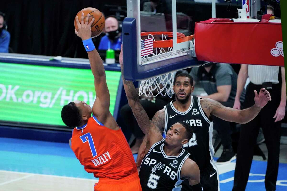 Oklahoma City Thunder forward Darius Bazley (7) goes up for a dunk in front of San Antonio Spurs guard Dejounte Murray (5) and forward Rudy Gay (22) in the second half of an NBA basketball game Tuesday, Jan. 12, 2021, in Oklahoma City. (AP Photo/Sue Ogrocki)