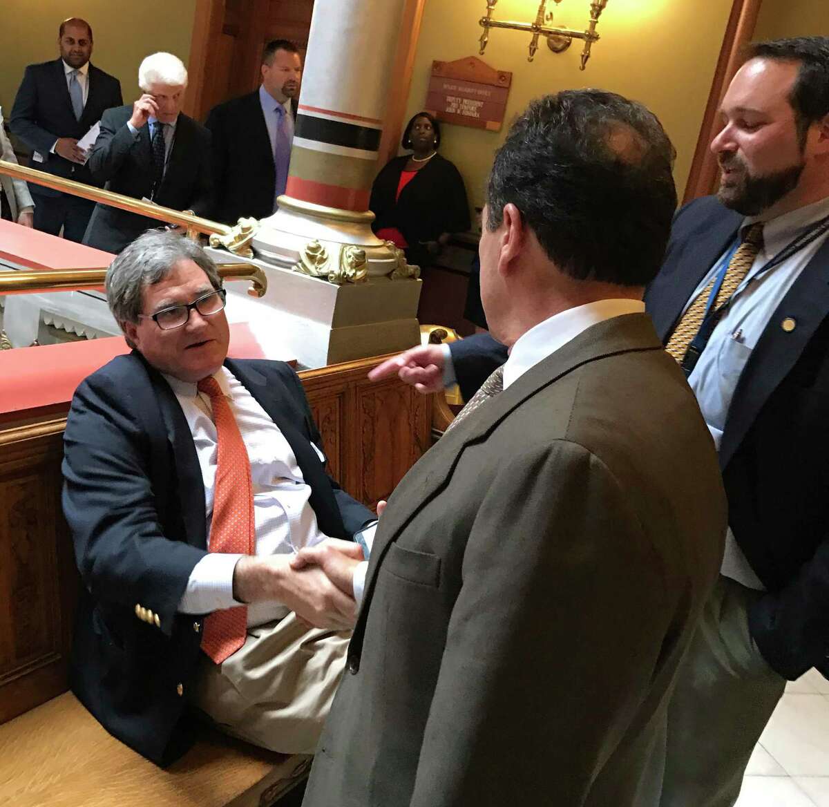 Former state GOP Chairman Chris Healy, seated, shook hands with Bridgeport Mayor Joe Ganim at the State Capitol in May, 2017.