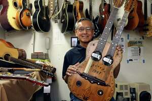 Mike Acosta, pictured at Acosta Music Co. in 2011, shows off a double-neck bajo sexto and guitar built by his father, Miguel. Mike Acosta, who ran the renowned family business until his retirement a few years ago, died Jan. 5 at age 81.