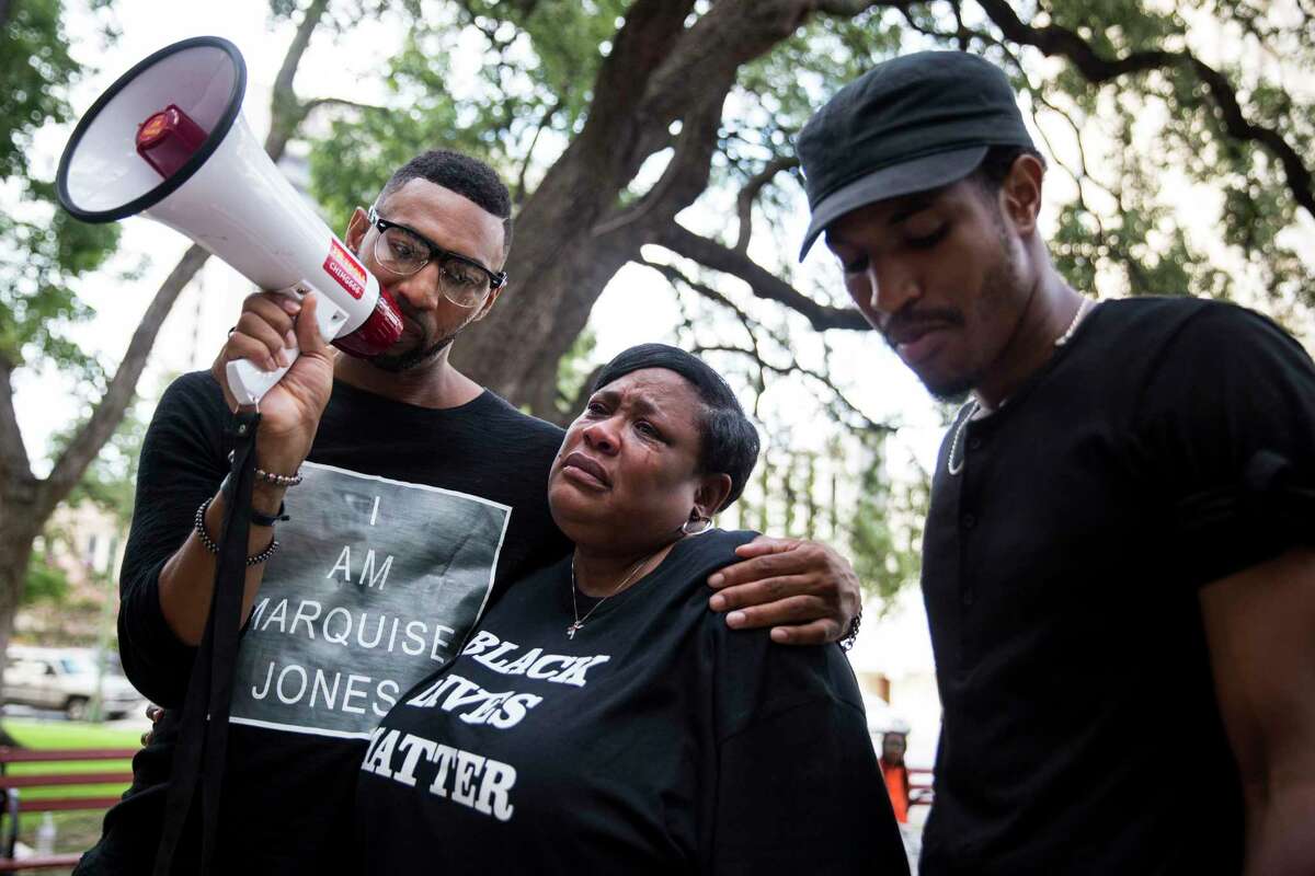 Deborah Bush, aunt of Marquise Jones who was killed by police, cries while Mike Lowe, left, and Johnathan-David Jones speak during a rally organaized by the Black Lives Matter movement before the San Antonio City Council meeting on August 31, 2016.