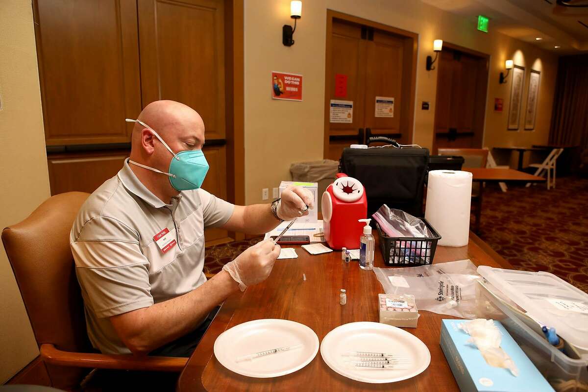 Mike Ring, a CVS pharmacy employee, adds a dose of the Pfizer COVID-19 vaccine into a syringe at Stoneridge Creek on Wednesday, January 13, 2021, in Pleasanton, Calif. Stoneridge Creek, a retirement community, has a 760 resident population and since Monday, 752 of them have been inoculated over a three-day period.