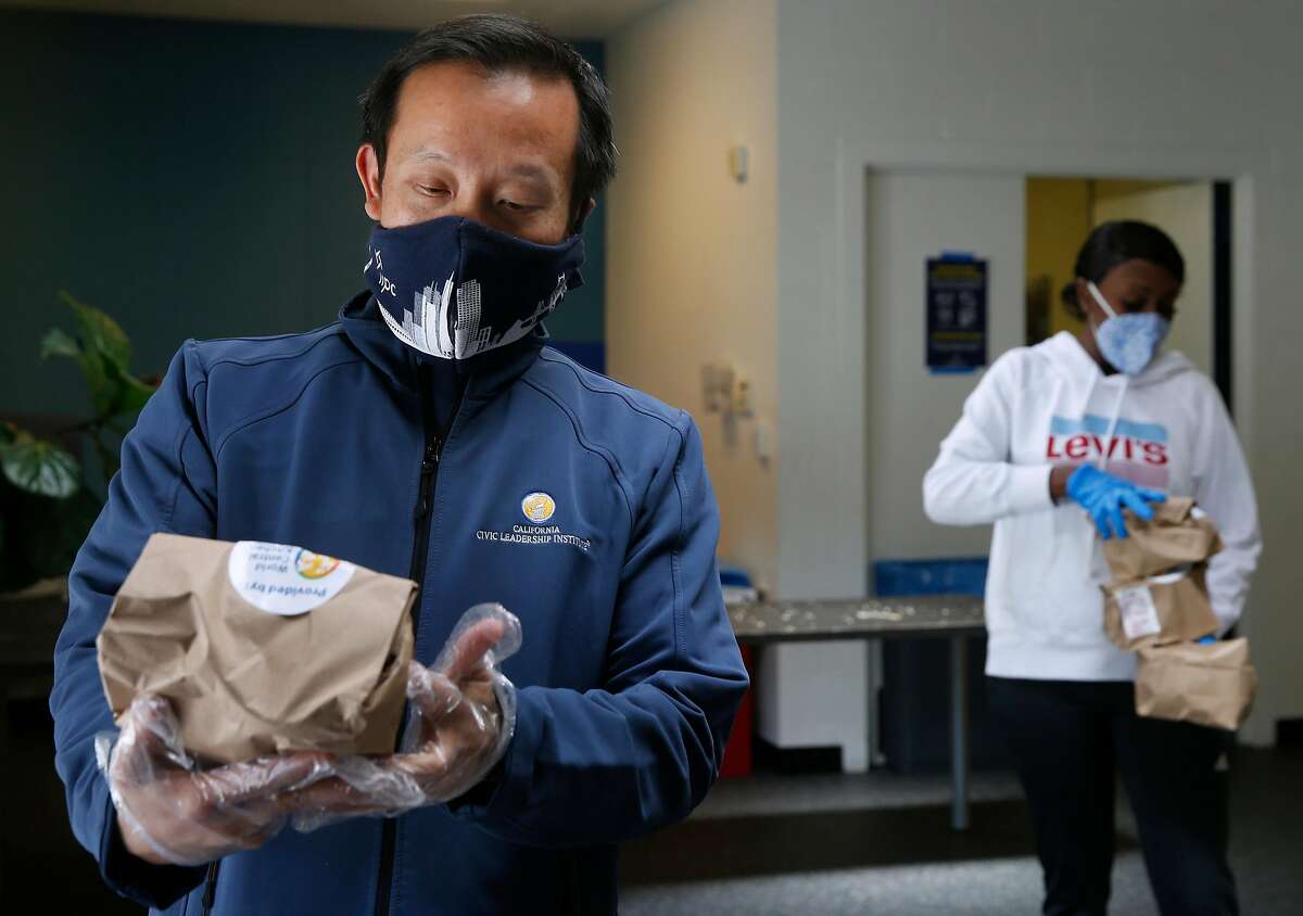 Assemblyman David Chiu gives lunches to neighborhood residents at the Ella Hill Hutch Community Center in San Francisco in April.