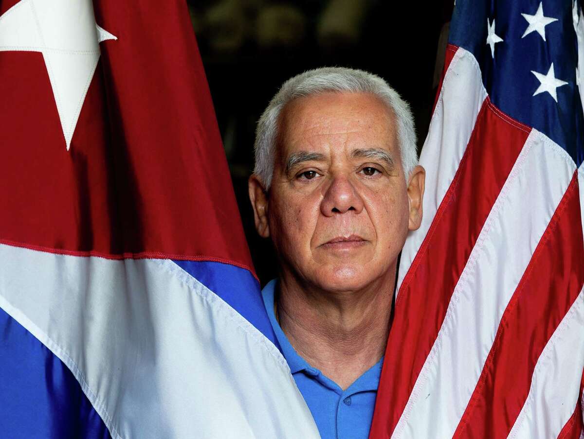 Renier Suárez poses with the Cuban and United States flags Friday, Jan. 8, 2021, in Houston. Suarez is a Cuban American business owner who was against the Cuban government for what he called its authoritarianism and is upset with President Trump for inciting Wednesday riot in the Capitol.