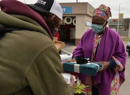 Pastor Shetigho Nakpodia give Joseph Castillo a blanket and a meal as part of her Redeemers Praise Church Outreach.