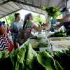 Shoppers make their way through the booths of farmers selling their goods at the Beaumont Farmer's Market Saturday morning. The market never closed, but tape marks off recommended distancing, and there are no booths set up in the center of the pavilion as in times past. Photo taken Saturday, May 30, 2020 Kim Brent/The Enterprise