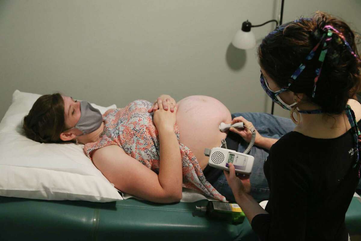 During a prenatal care visit, Certified Nurse Midwife Annie Leone, right, listens to the heartbeat of Melissa Woodfin child at the Holy Family Birth Center in Weslaco, Texas, Thursday, Sept. 3, 2020. Woodfin was 37 weeks pregnant and was planning on using the center for the birth. The center was started by Catholic nuns in 1983 and is the only free-standing birth center operated by certified nurse-midwives in the Rio Grande Valley.