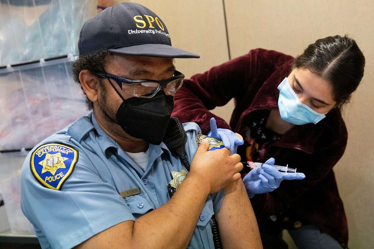 UC Berkeley University Health Services nurse Andrea Gomez administers a dose of the Moderna vaccine to University of California police officer Leo Warrens at Tang Center near UC Berkeley on Thursday. Experts worry that vaccinations might not keep pace with the spread of new, highly contagious coronavirus variants.
