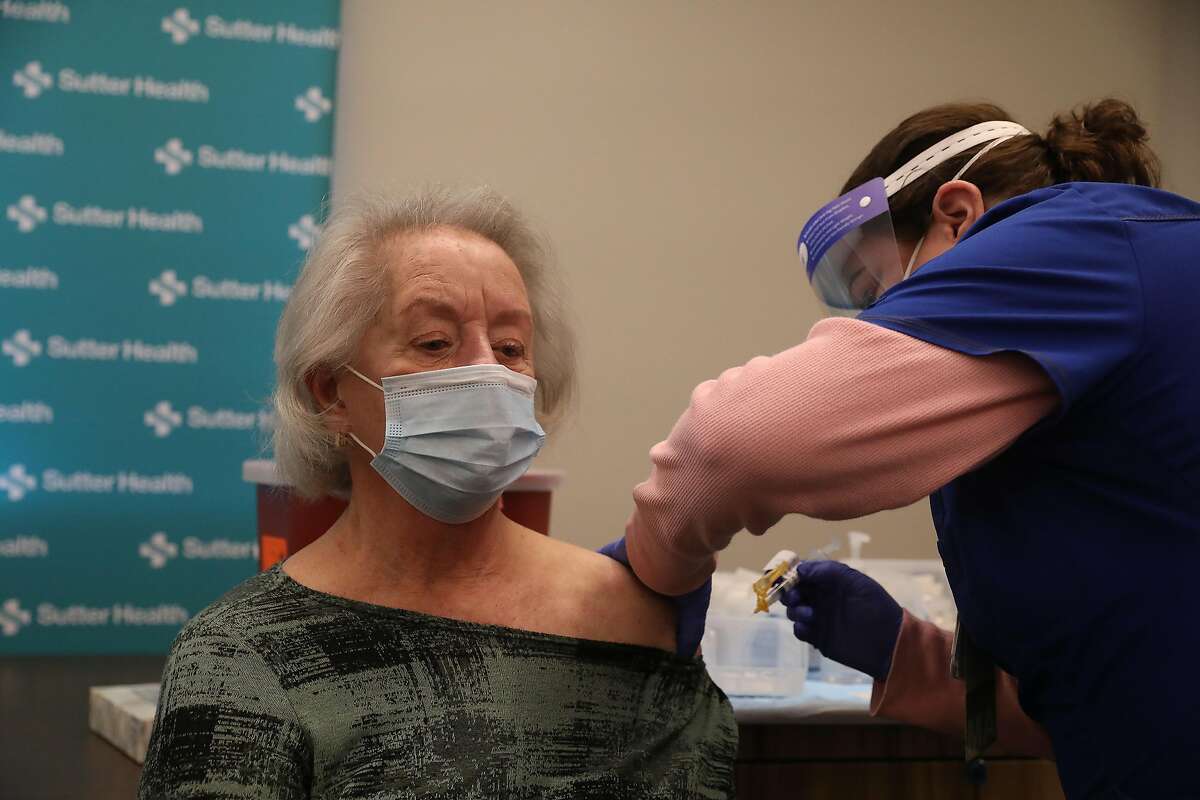 Marian Sullivan (left) of San Francisco receives the Moderna COVID-19 vaccination from medical assistant Lori Viramontes (right) at the new COVID-19 vaccination clinic at Sutter Health in San Francisco on Thursday, January 14, 2021 in San Francisco, Calif. Sutter Health is only vaccinating seniors aged 75 and older and not yet vaccinating those seniors 65-74 years old.