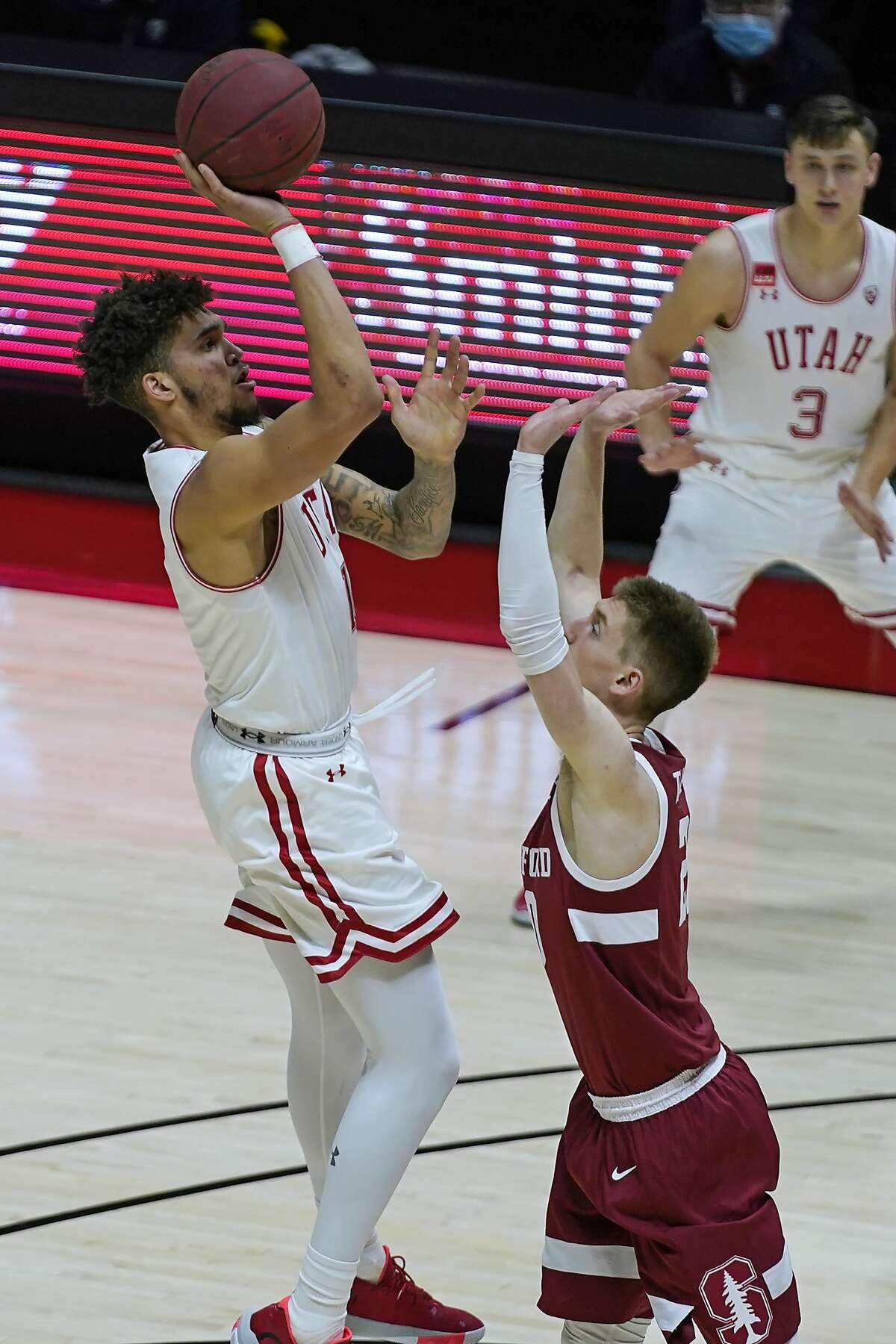 Utah forward Timmy Allen, left, shoots over Stanford guard Noah Taitz during the second half of an NCAA college basketball game Thursday, Jan. 14, 2021, in Salt Lake City. (AP Photo/Rick Bowmer)