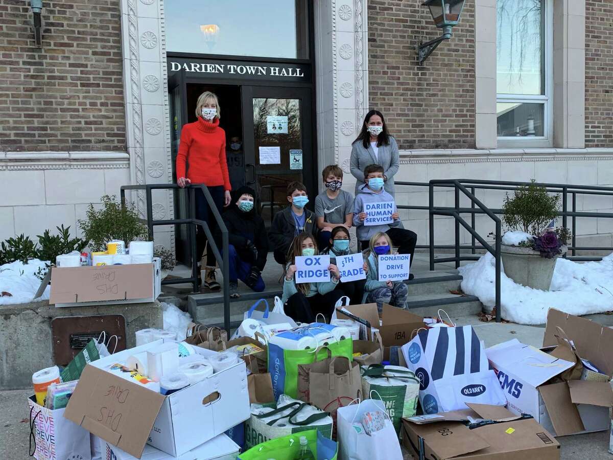 Diane Barston, program assistant, left, and Ali Ramsteck, director of Darien Human Services with all the donations and fifth grade students from Ox Ridge Elementary School.