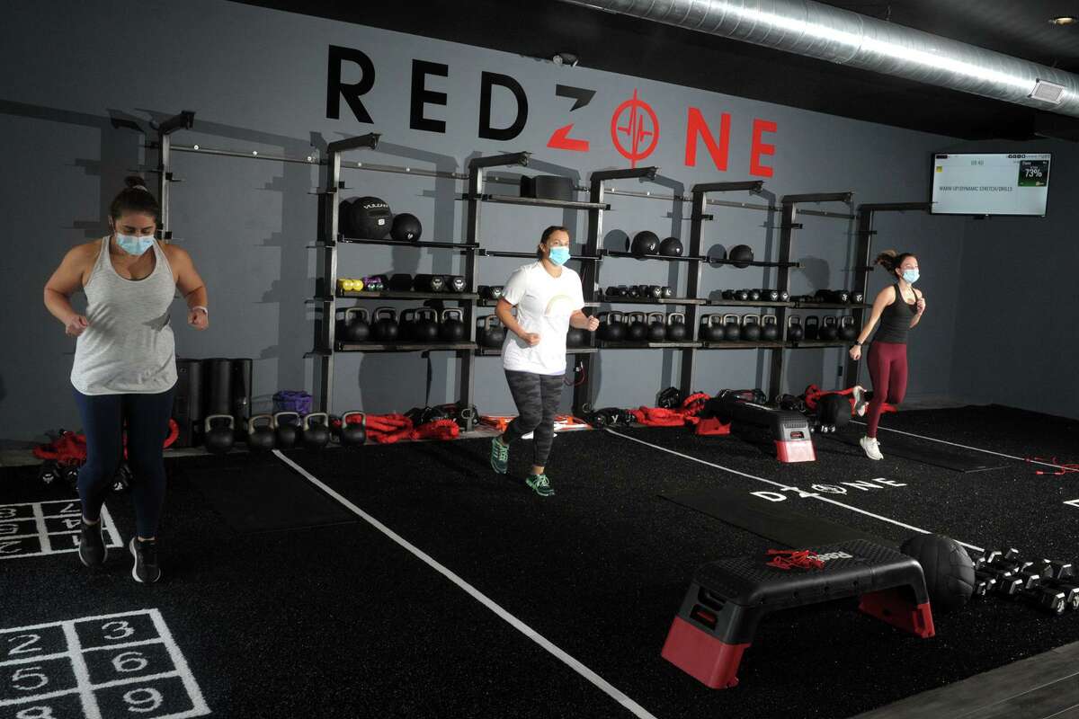 RedZone members work out at a new fitness center in Weston, Conn., adhering to mask and distance rules in effect under Connecticut’s “2.1” safeguards to limit any transmission of COVID-19.