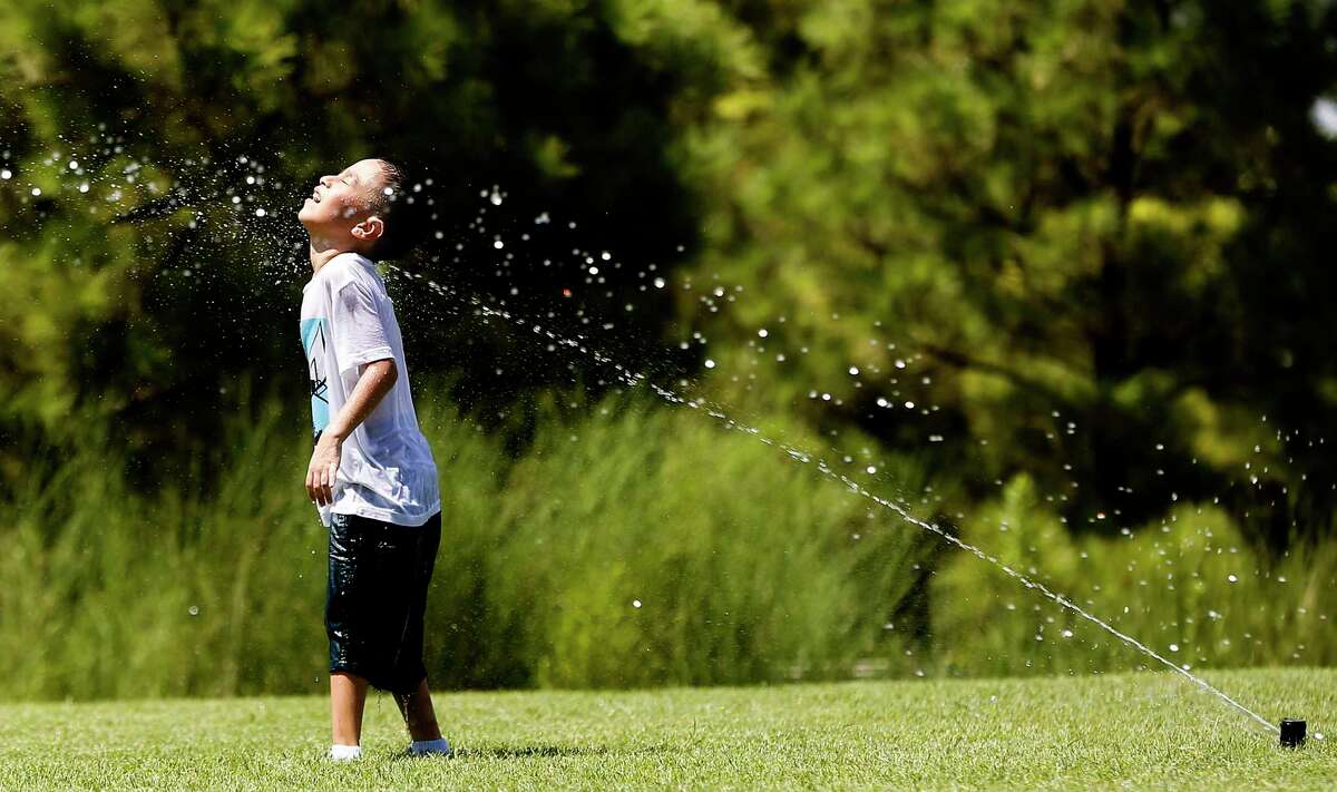 Adam Castro, 6, cools off in sprinklers at Buffalo Bayou Park in Houston on Thursday, Aug. 13, 2020. 2020 will go down as one of the warmest years in recorded history so far.