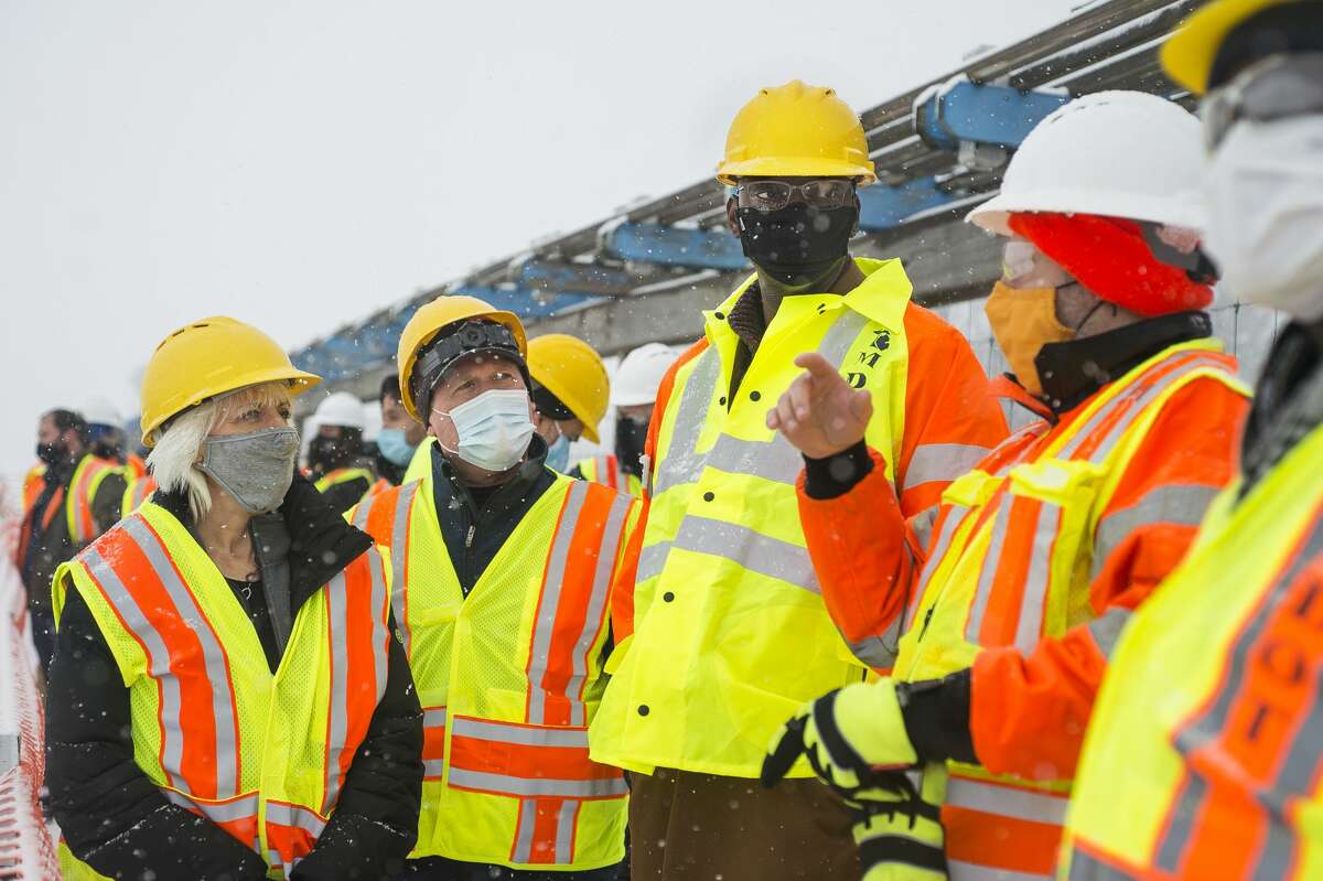 From left, State Rep. Annette Glenn, State Rep. Roger Hauck and Michigan Lt. Governor Garlin Gilchrist, chat with MDOT Construction Engineer Shaun Bates, right, as they tour the construction site of the temporary M-30 bridge over the Tobacco River Friday, Jan. 15, 2021. (Katy Kildee/kkildee@mdn.net)