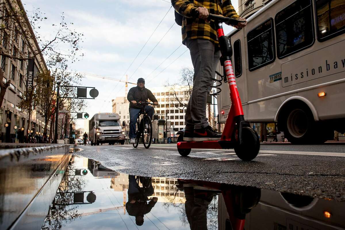Shuttle buses, cyclists and scooters move along Market Street in San Francisco last January. That month, private vehicles were banned along Market Street between Steuart and 10th streets, leaving it free for cyclists, pedestrians and public transit vehicles.