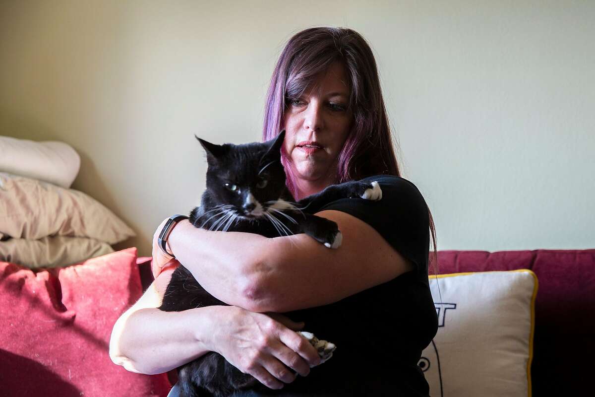 A portrait of Shelly Ross and her cat Tyler Purrden at their home, Friday, Jan. 15, 2021, in San Francisco, Calif. Shelly Ross, who runs cat-sitting services Tales of the Kitty, is among thousands of Californians whose unemployment benefits were frozen by the state, amid the coronavirus pandemic.