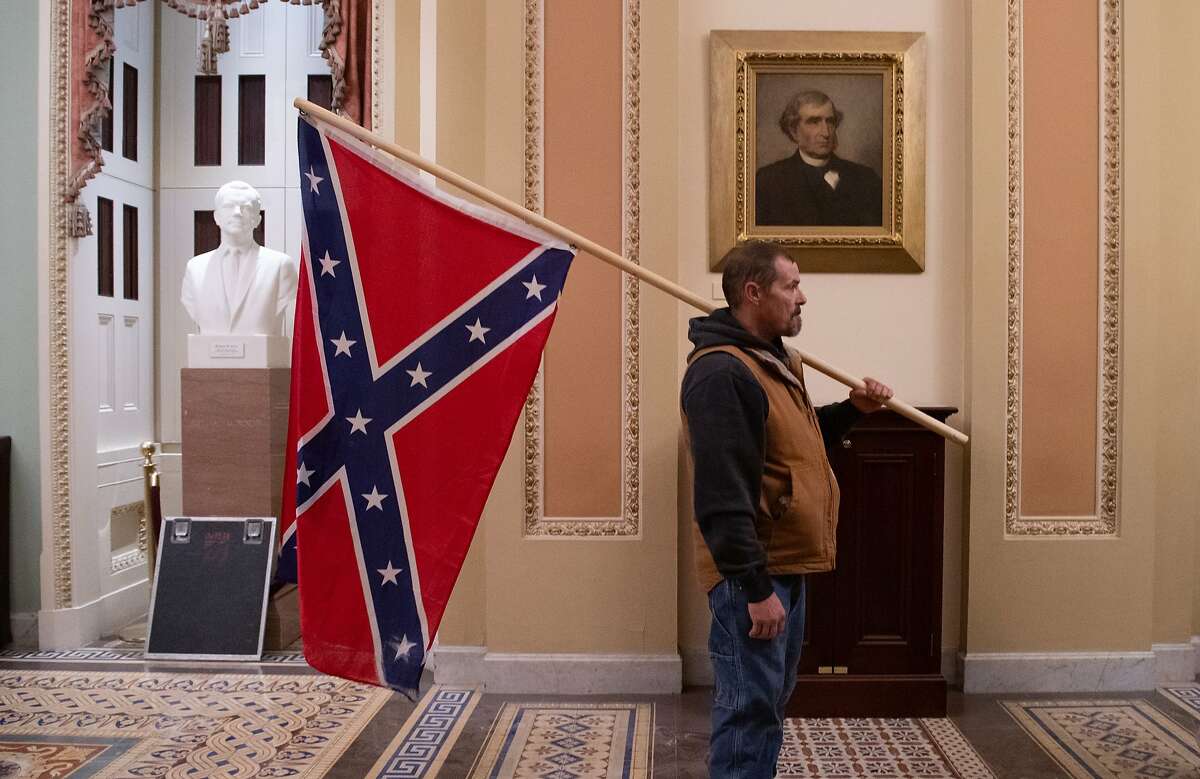 A Trump supporter with a Confederate flag outside the Senate Chamber during the Capitol riot.