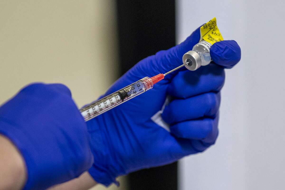 The Pfizer-BioNTech coronavirus vaccine is prepared to be administered during a vaccine event at a Kaiser Permanente medical center in Washington in December. In California, huge demand for the vaccine has triggered long wait times at Kaiser call centers.