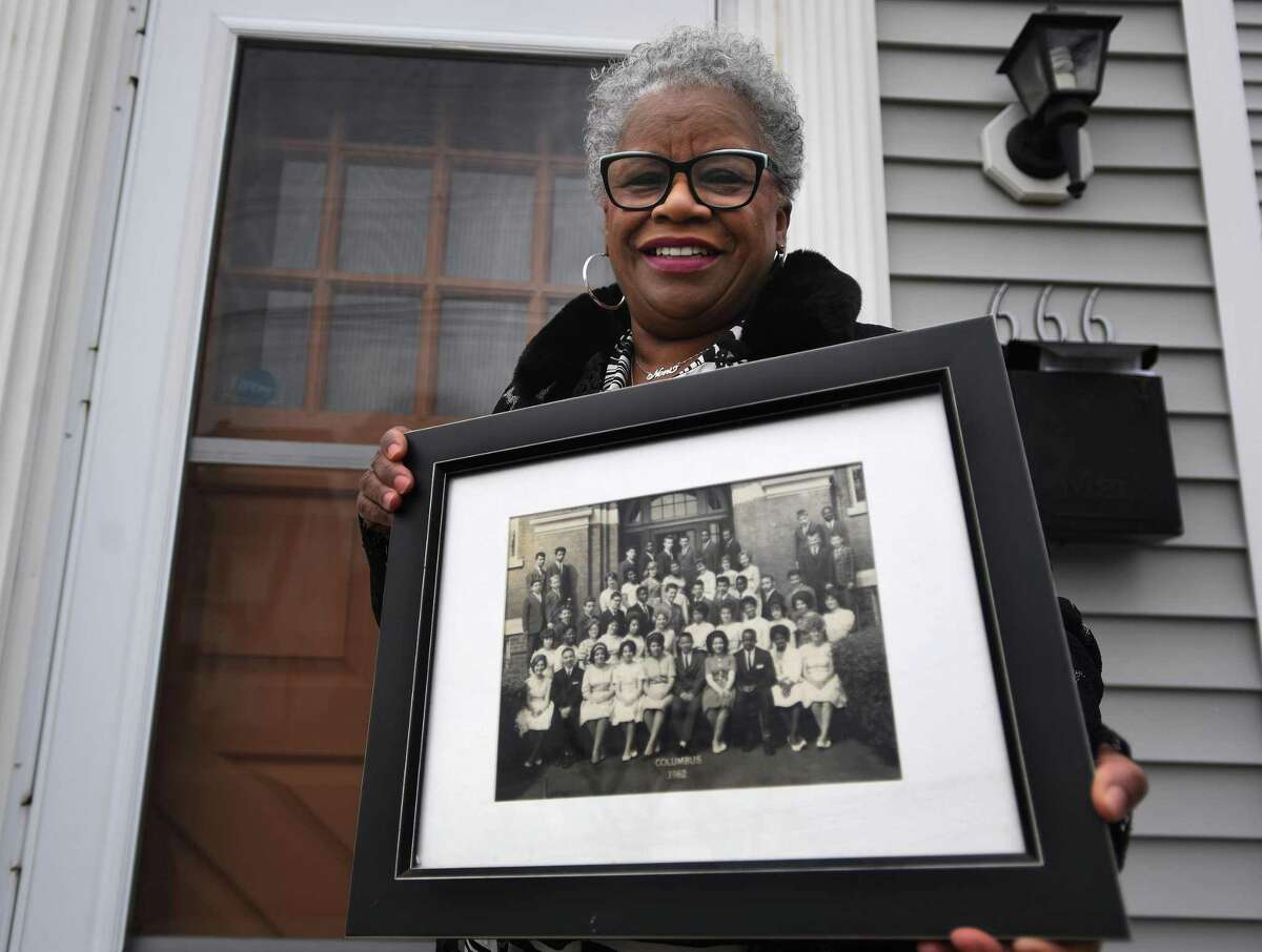 State Senator Marilyn Moore holds the photo of her 8th grade 1962 graduating class from Columbus School in Bridgeport, Conn. on Thursday, January 14, 2021. At Columbus, Moore met teacher and civil rights activist Charles Tisdale, who introduced her to the movement.