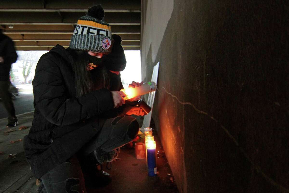 Organizer Kira Ortoleva lights a candle for a vigil held in memory of Mubarak Soulemane at the I95 overpass along Campbell Avenue in West Haven, Conn., on Friday Jan. 15, 2021. Soulemane, a New Haven resident, was fatally shot by state Trooper Brian North after a car chase on Jan. 15, 2020.