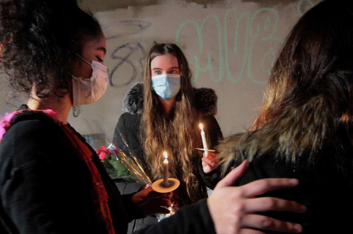 Amelia Sullivan, center, attends a vigil held in memory of his friend Mubarak Soulemane at the I95 overpass along Campbell Avenue in West Haven, Conn., on Friday Jan. 15, 2021. Soulemane, a New Haven resident, was fatally shot by state Trooper Brian North after a car chase on Jan. 15, 2020.