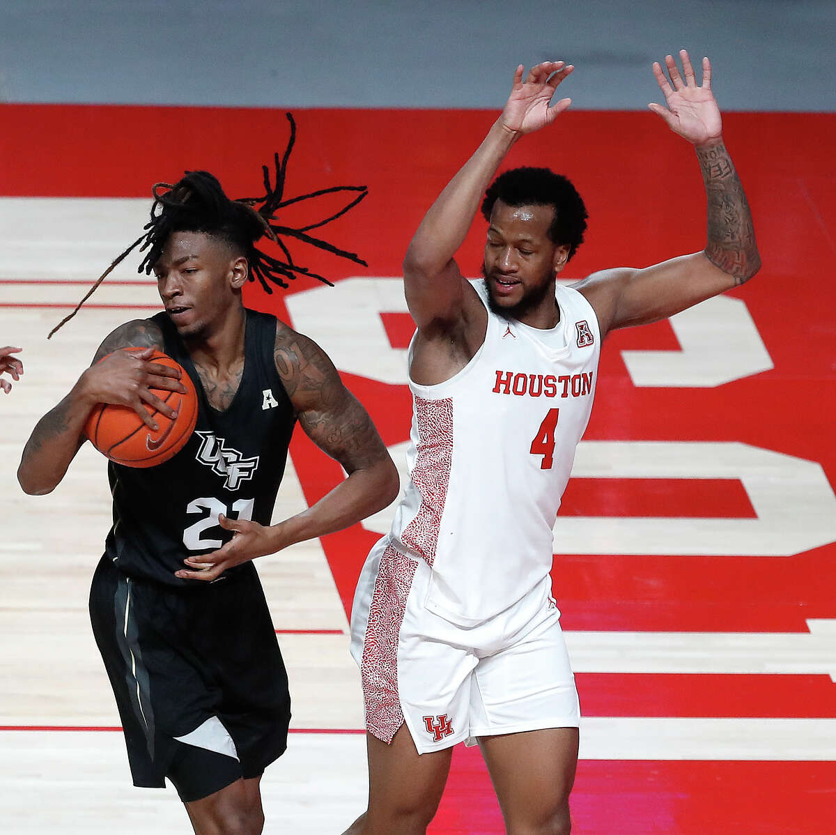 UCF Knights forward C.J. Walker (21) grabs the rebound from Houston Cougars forward Justin Gorham (4) during the second half of a men’s NCAA basketball game at the Fertitta Center, in Houston, Sunday, Jan. 17, 2021.