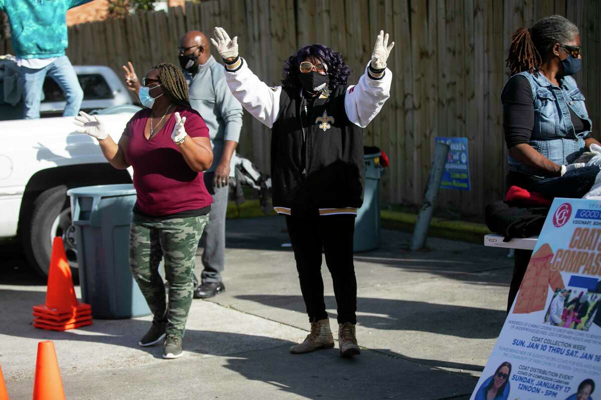 Virginia Dutton cheers for a shout-out as she helps hand out over 2,000 coats to community members in north Houston on Sunday, Jan. 17, 2021. Dutton joined other members of the Community of Faith Church for their annual giveaway.