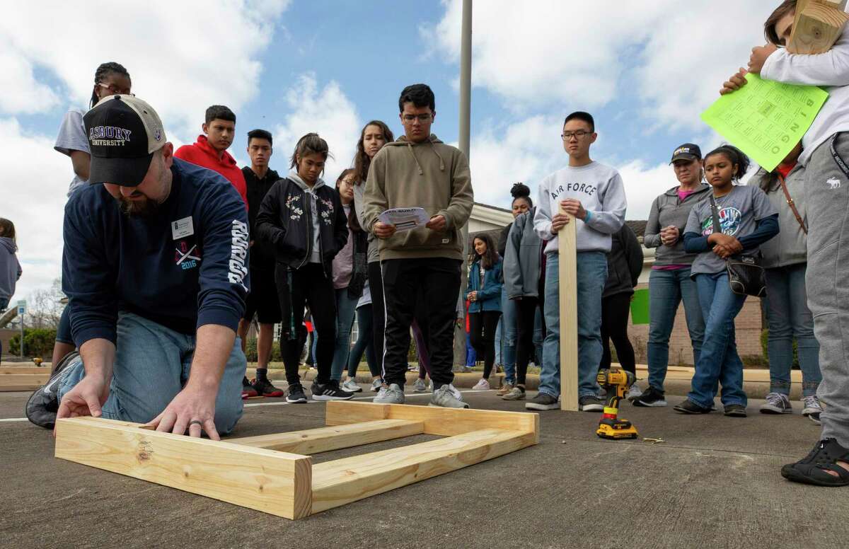 Christ Church Sugar Land student minister Todd Harris, left, shows teenagers from the Fort Bend Interfaith group how to put together a headrest outside on Martin Luther King Jr. Day on Monday, Jan. 21, 2019, in Sugar Land.