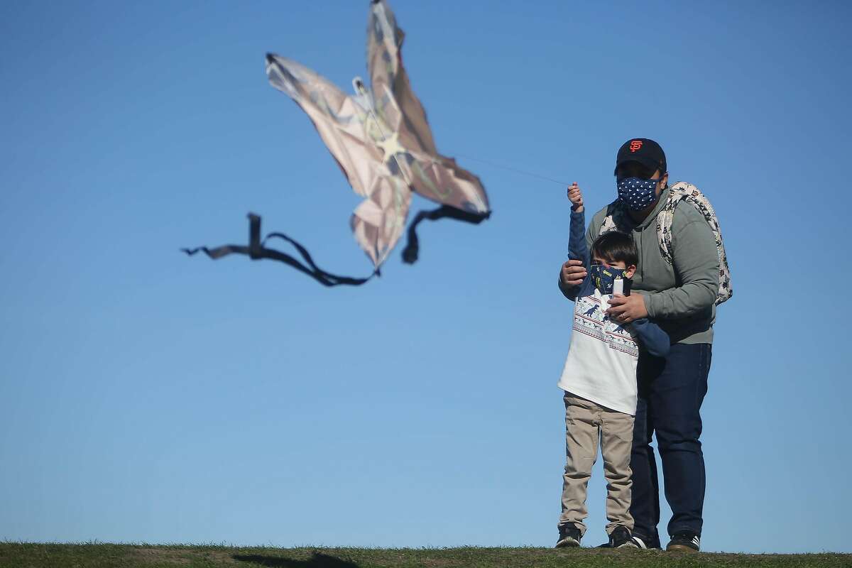 Lorraine Esturas-Pierson (right) and her son Wilder Esturas-Pierson (left), 4, both of Emeryville, fly their kite on top of a hill at at C�sar E. Ch�vez Park on Monday, January 18, 2021 in Berkeley, Calif. On Monday, Wilder was able to fly a kite for the first time after an unsuccsessful attempt at the park the day before. The National Weather Service issues a high wind advisory on Monday with high winds continuing until Tuesday.