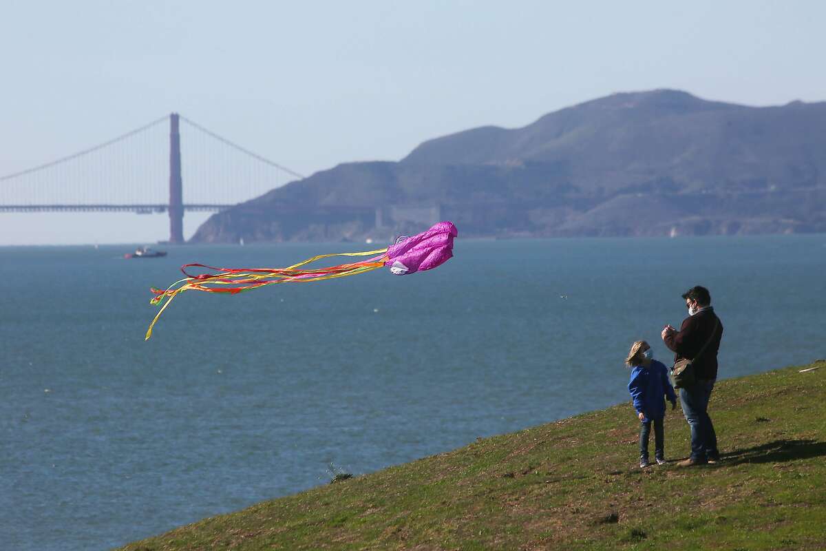 Adam Gerardin (right) and his daughter Nia Gerardin (left), 6, both of Richmond, fly their kite from the top of a hill at at C�sar E. Ch�vez Park on Monday, January 18, 2021 in Berkeley, Calif. The National Weather Service issues a high wind advisory on Monday with high winds continuing until Tuesday.