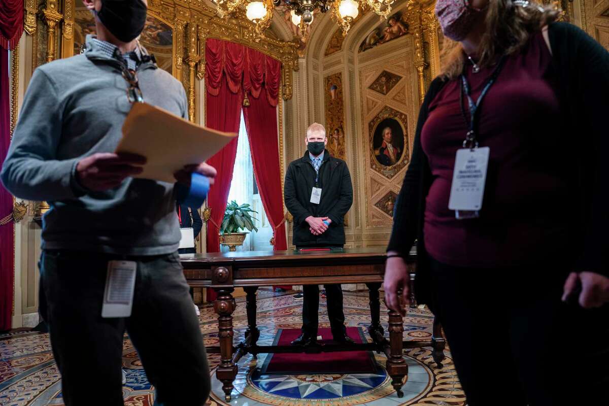 A stand-in for President-elect Joe Biden, center, stands in the President's Room of the U.S. Capitol during a rehearsal for the 59th Presidential Inauguration on Monday, Jan. 18, 2021, in Washington. (Jim Lo Scalzo/Pool via AP)