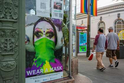 Men holding hands walk past the Twin Peaks Tavern on Friday, Jan. 15, 2021, in San Francisco, Calif. The tavern is closed, amid the coronavirus pandemic. The place is in danger of closing and is raising contributions to pay for rent and operations.