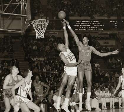 The Knicks' Tom Hoover and San Francisco's Wilt Chamberlain (13) do some fingertip stretching for elusive ball in the early 1960s.