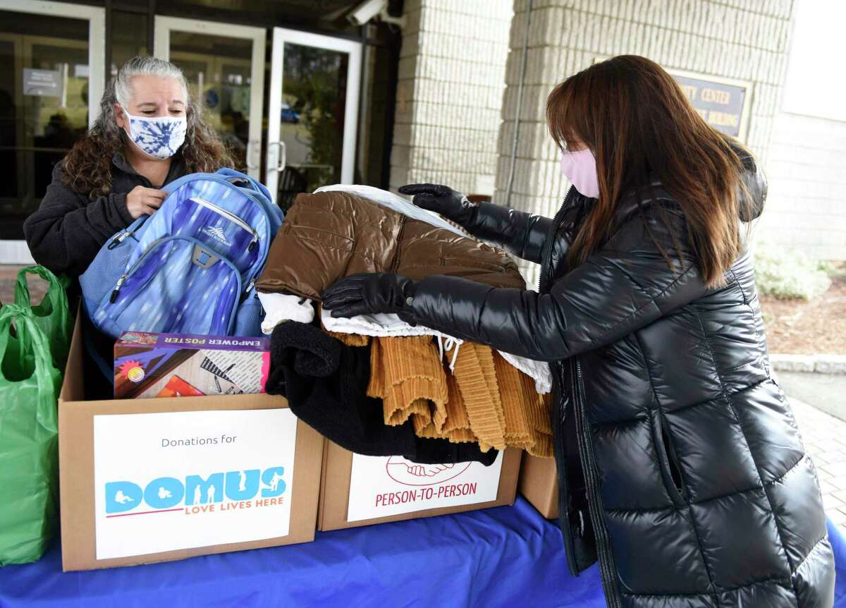 Volunteer Jami Birnbaum, left, and JCC board member Jeannie Kriftcher collect donations outside the JCC in Stamford, Conn. Monday, Jan. 18, 2021. Stamford JCC celebrated Martin Luther King Day with a day of service by collecting donations of art supplies for Stamford Public Schools, groceries and grocery store gift cards for New Covenant Center, games and backpacks for DOMUS, winter coats for Person to Person, and winter accessories for Jewish Family Services of Fairfield County.