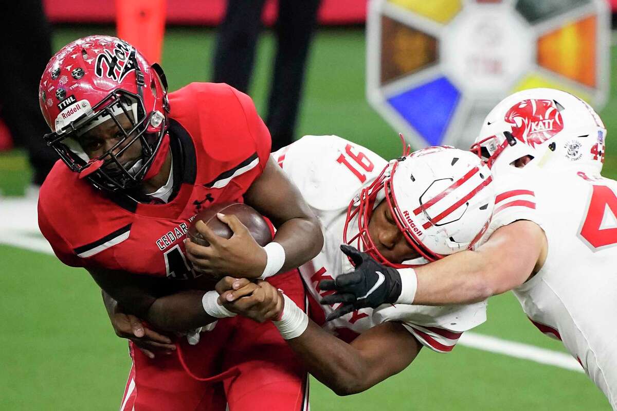 Cedar Hill wide receiver Dewayne Blanton (15) is wrapped up by Katy defensive lineman Cal Varner (91) during the second half of the Class 6A Division II state football championship game Saturday, Jan. 16, 2021, in Arlington, Texas. (Smiley N. Pool/The Dallas Morning News via AP)
