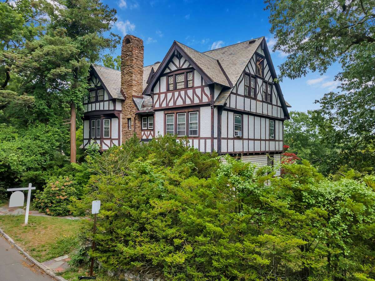 Tudor-style house at 5 St. Ronan Terrace, in a historic New Haven neighborhood. Chances are the former resident, Joan Panetti, was inspired by her surroundings within this 12-room, 6,228-square-foot house, which includes ornate hand-carved wood doors, fluted pilasters and other millwork and moldings, a decorative newel post and railings, elegant entablature, Corinthian columns, etched glass-paned French doors and four fireplaces – one of them with a floor-to-ceiling surround of in-lay details and ivory tiles. At the front entrance there is a solid iron gate depicting medallions of Tudor roses.  The house was built in 1903 “during a time when attention to detail was second to none,” according to Erin Connelly, the co-listing agent. The craftsmanship is not found in modern construction and, in fact, would be prohibitively expensive to replicate today.   